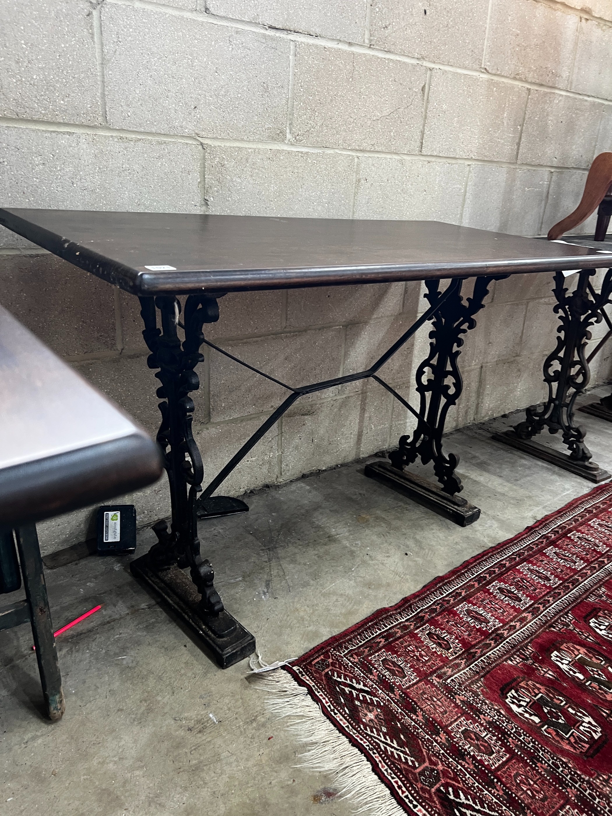 Two Victorian style cast metal stained wood topped tavern tables, larger width 120cm, depth 60cm, height 75cm